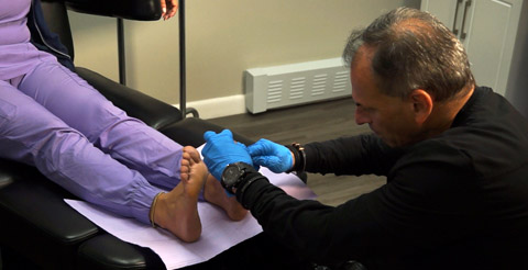 Dr. Mitchell Wacthel is assessing a patient's foot pain.